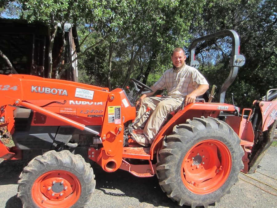 Greg on his tractor ready for clearing, plowing, feeding the pigs, you name it.